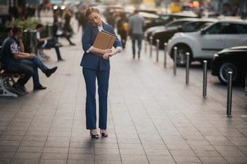 Fototapeta premium Busy woman is in a hurry, she does not have time, she is going to talk on the phone on the go. Businesswoman doing multiple tasks. Multitasking business person.