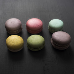 multicolored macaroon on a dark wooden table