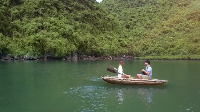 Drone Shows Girl and Man Rowing on Boat on Lake by Ha Long Bay