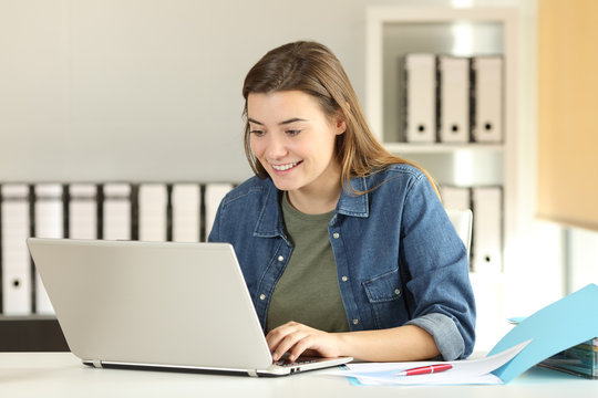 Happy intern teenager working at office