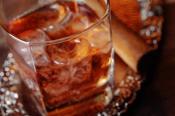 Glass of  whiskey and cigar on old wooden table.