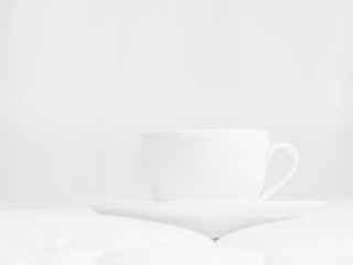 Black and white tone of coffee cup, white floor and grey wall.