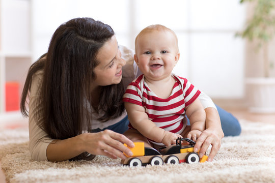 cute mother and child boy play together with toys indoors at home