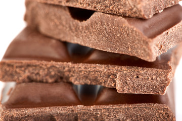 Milk chocolate pieces isolated on white background.