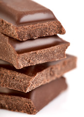Milk chocolate pieces isolated on white background.