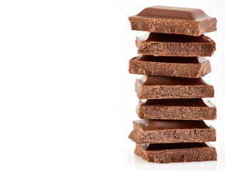 Milk chocolate pieces isolated on white background.