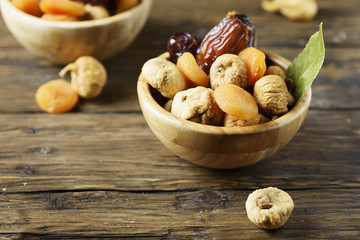 Fototapeta na wymiar Sweet italian dried figs, apricots and dates on the wooden table