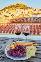 Red wine with delicious cheese, bread and grapes