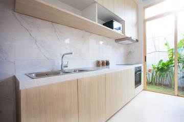 Luxury interior design in living room of pool villas. Airy and bright space with high raised ceiling and wooden dining table