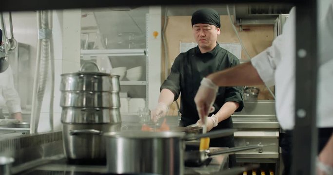 backstage workflow in the kitchen of the restaurant, the team of Asian chefs work with vegetables, cooking vegetarian dishes