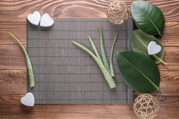 Aloe vera leaves on wooden table. Natural cosmetic ingredients with copy space. Fresh aloe vera plant on wooden board, flat lay. Spa concept, top view.