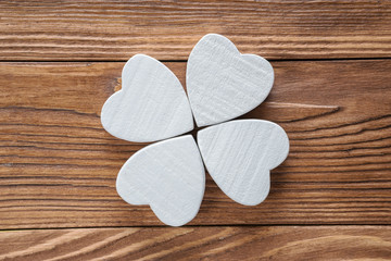 Fototapeta premium Abstract clover on wood background, top view, flat lay. Abstract white wooden clover, close-up.