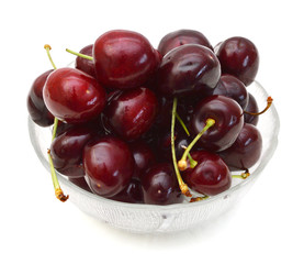 fresh cherries on  glass bowl over white
