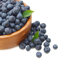 Blueberries in wooden bowl on white background