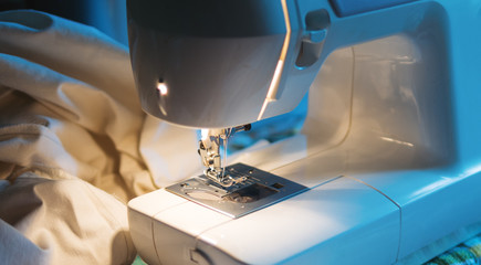 a sewing machine in the workplace. sewing white fabric