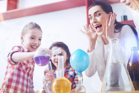 You driving out of my mind. Shocked female teacher of chemistry screaming while watching the group of elementary students disobeying her and trying to mix different chemical substances
