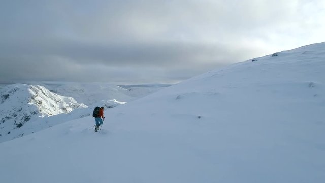 Mountain Climber Walking Close to the Summit of a Snowy Mountain