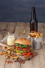 Big tasty burger and fries on background on the wooden table