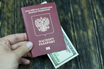 Hand holds a passport with money