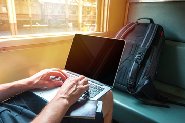 Digital nomad man working on a laptop in a train
