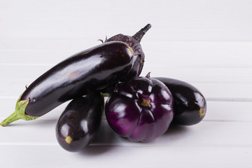 Purple eggplants of different color and variety on the white background.