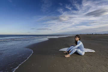 Fototapeta na wymiar Mujer joven oriental cerca del mar tabla de surf