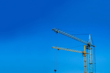 Two cranes against the blue sky.
