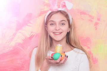 Obraz na płótnie Canvas happy easter girl in bunny ears with colorful painted eggs