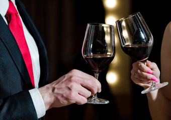 cheers, couple clink glasses with red wine
