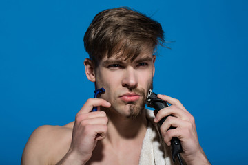 Man shave with safety and electric razor on blue background