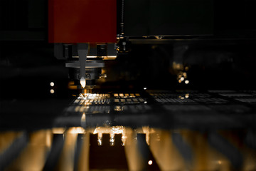 Fototapeta na wymiar CNC laser cutting metal sheet with bright sparkle