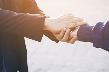 Close up on a man and a woman holding hands in the park