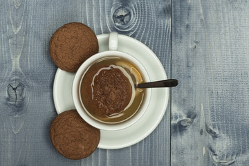 Cookies near tea cup on wooden grey background.
