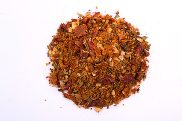 A pile of a  spice mix for meat  . Isolated on white background. Spices consist paprika onion...