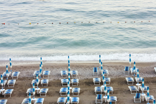 Rows of deckchairs and umbrellas placed on beach