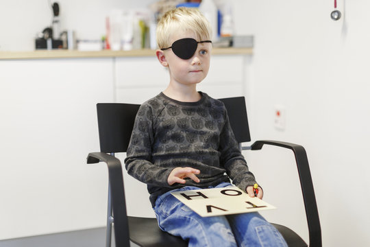 Little boy wearing eyepatch during eye examination