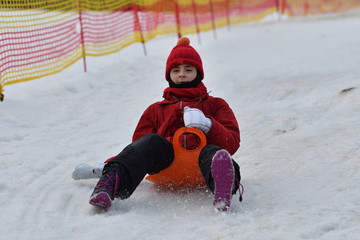 Fototapeta na wymiar Family girl man woman sledding on the snow from the winter hill