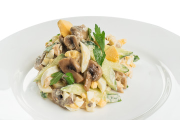salad of fresh vegetables, boiled eggs and fried mushrooms, with mayonnaise on a white plate