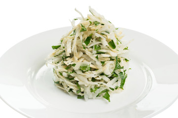 salad of white cabbage and celery with parsley on a white plate