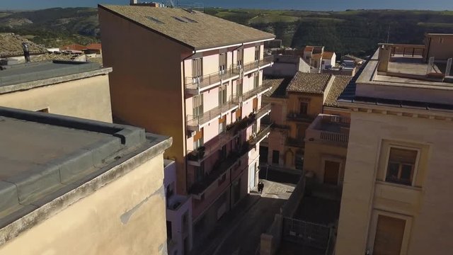 flying backwards reveal of sculptures atop fascist Ragusa post office
