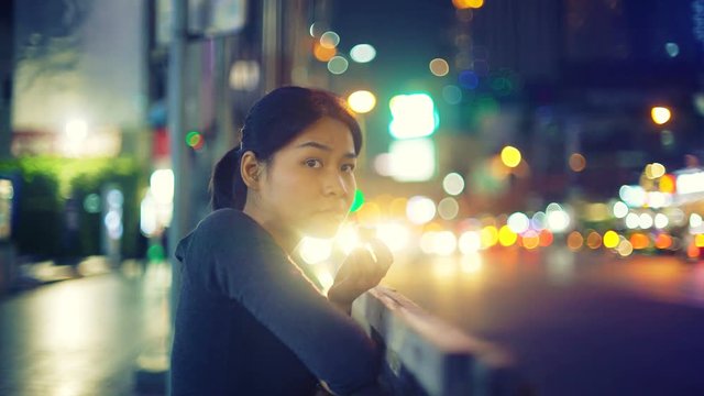 Asian Girl eating ice cream on street of night city