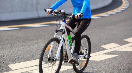 Naklejka premium Young Woman Cyclist Riding Mountain Bike on city road.