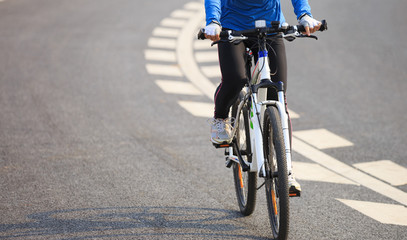 Fototapeta na wymiar Young Woman Cyclist Riding Mountain Bike on city road