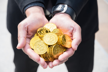 Close up, bitcoins are holding by business man's hands