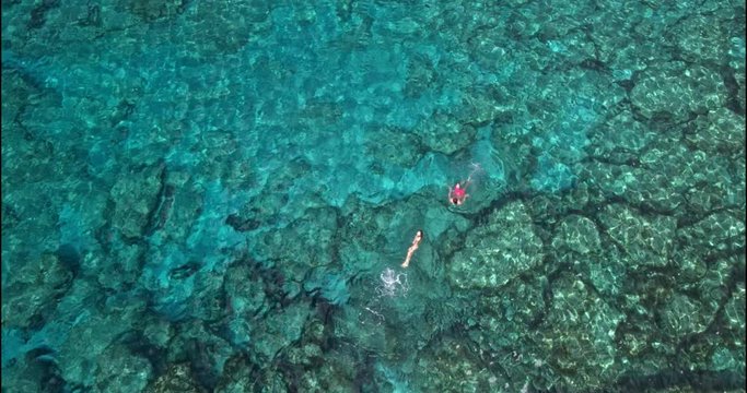 Aerial view of couple swimming in blue sea water