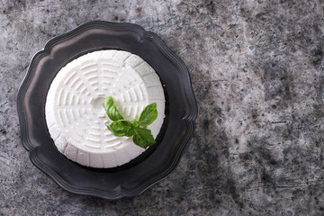 A fresh ricotta with basil leaf on wooden table italian food concept