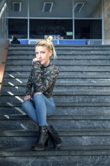 Blonde young girl sitting at the stairs