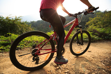 Fototapeta na wymiar Riding mountain bike on forest trial during sunrise .