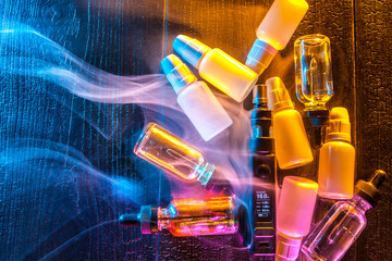 A concept with an electronic cigarette. Vape. Bottles with liquid for electronic cigarette.  A...