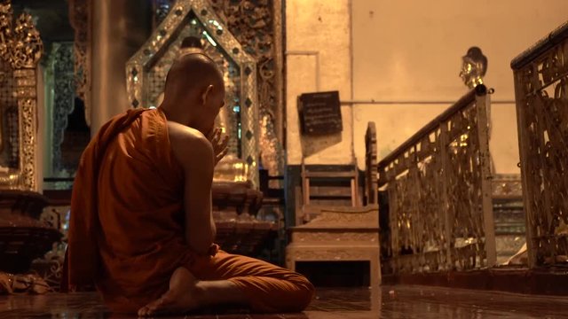 Burmese Unrecognizable Monk Praying in Buddhist Temple at Night